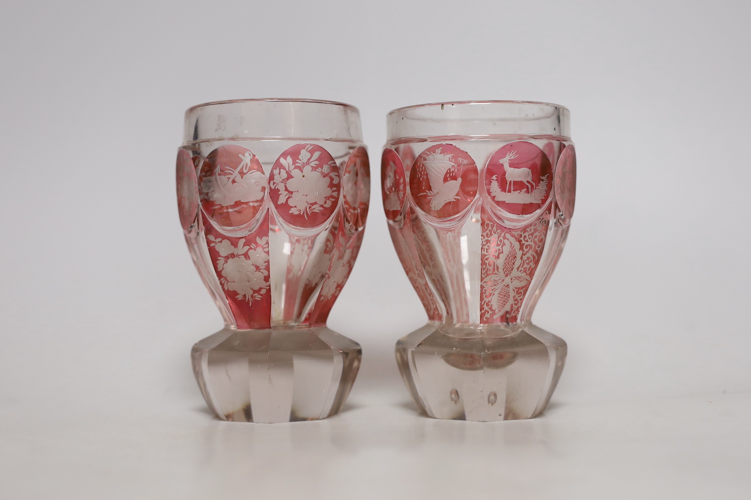 A pair of late 19th century Bohemian wheel engraved ruby stained glass beakers, 13.5cms high
